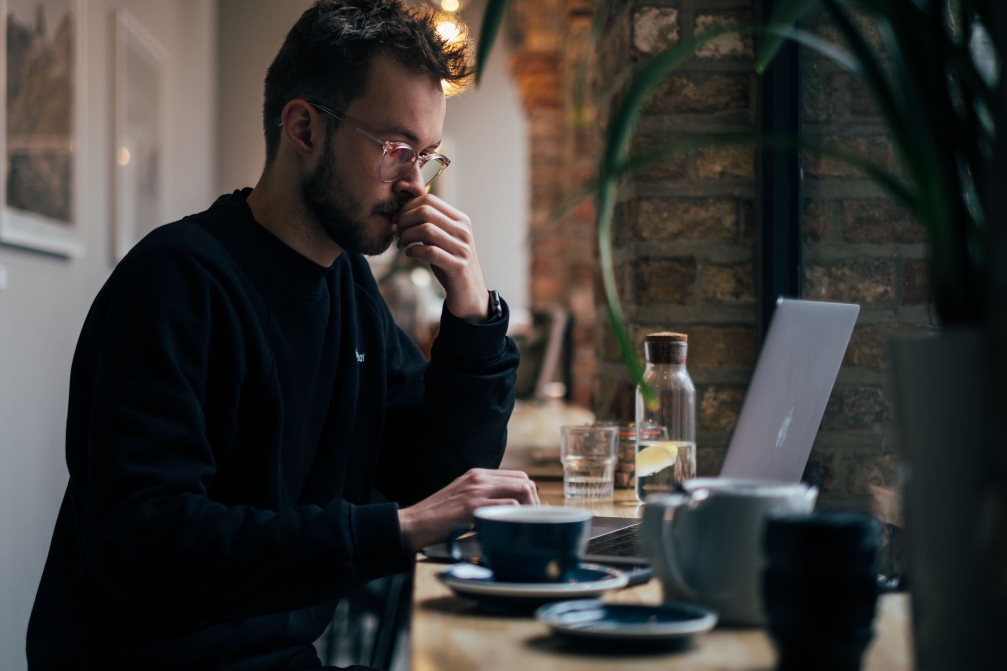 Man reviewing a laptop at a café table