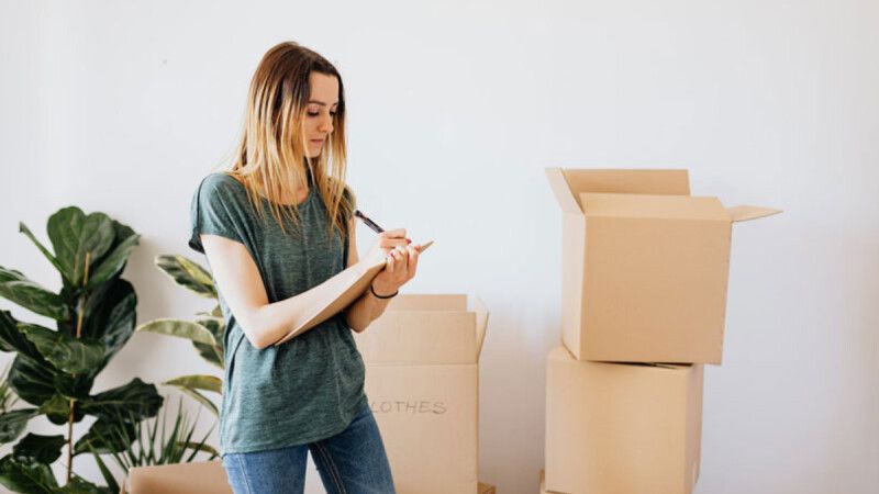 Woman holding a key beside moving boxes