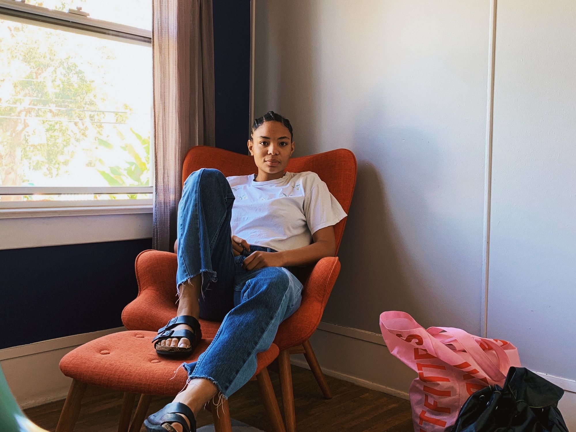 Woman relaxing in an armchair beside a bright window